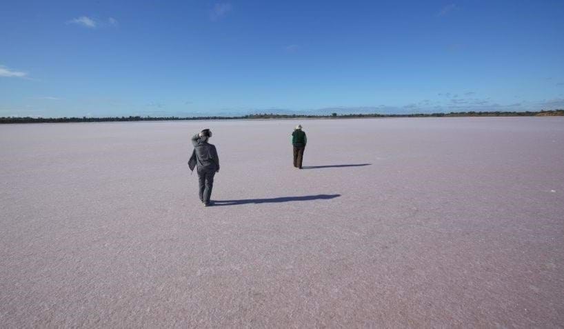 Two people walking across Pink Lakes in Murray-Sunset National Park