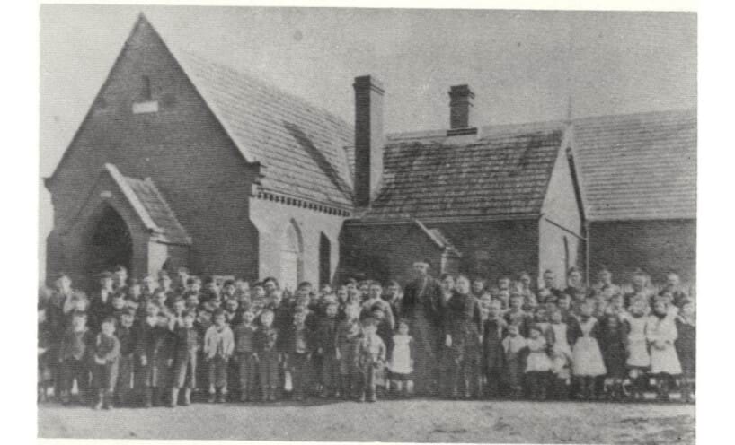 Portrait of school students in front of Winters Flat State School date unknown.