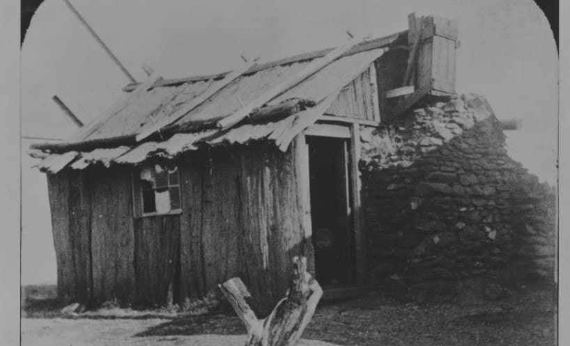 Single story timber school building with stone chimney at Boots Gully School in 1859