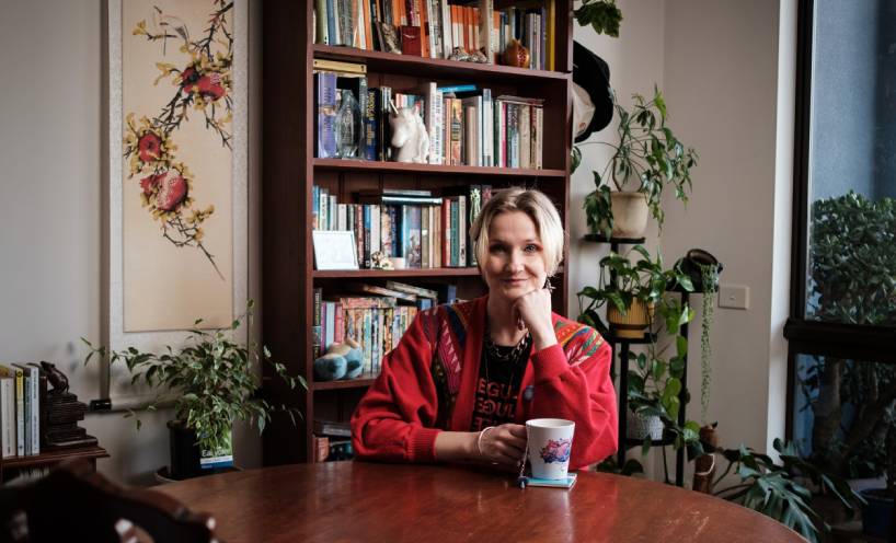 Ruby Mountford sitting at a table in front of a bookcase