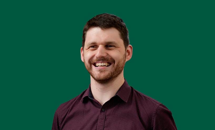 Image of male graduate in front of green background