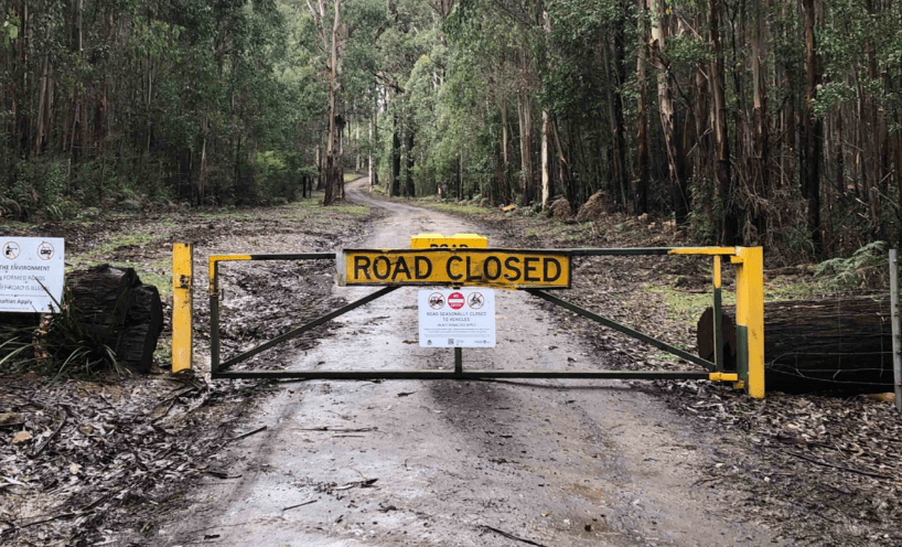Dirt road with gate closed and "road closed" sign