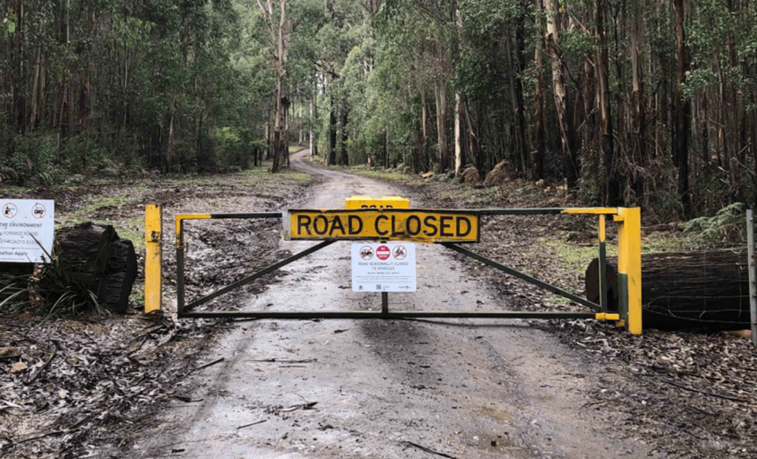 Dirt road with gate closed and "road closed" sign