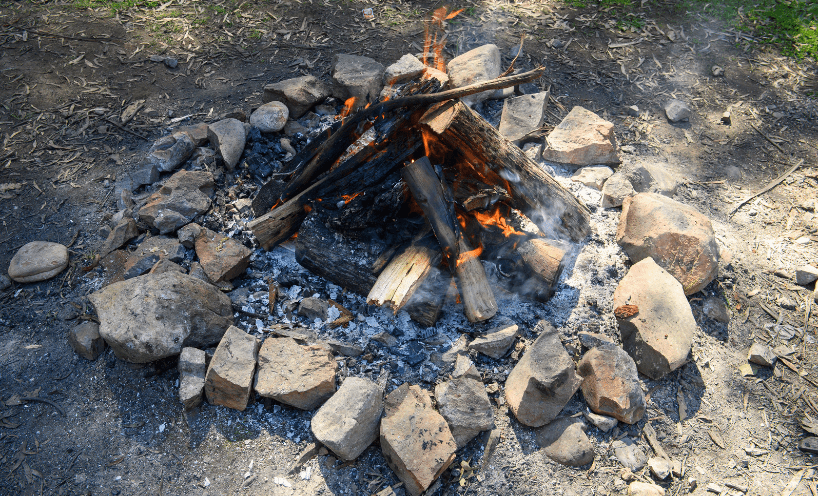A lit campfire surrounded by rocks