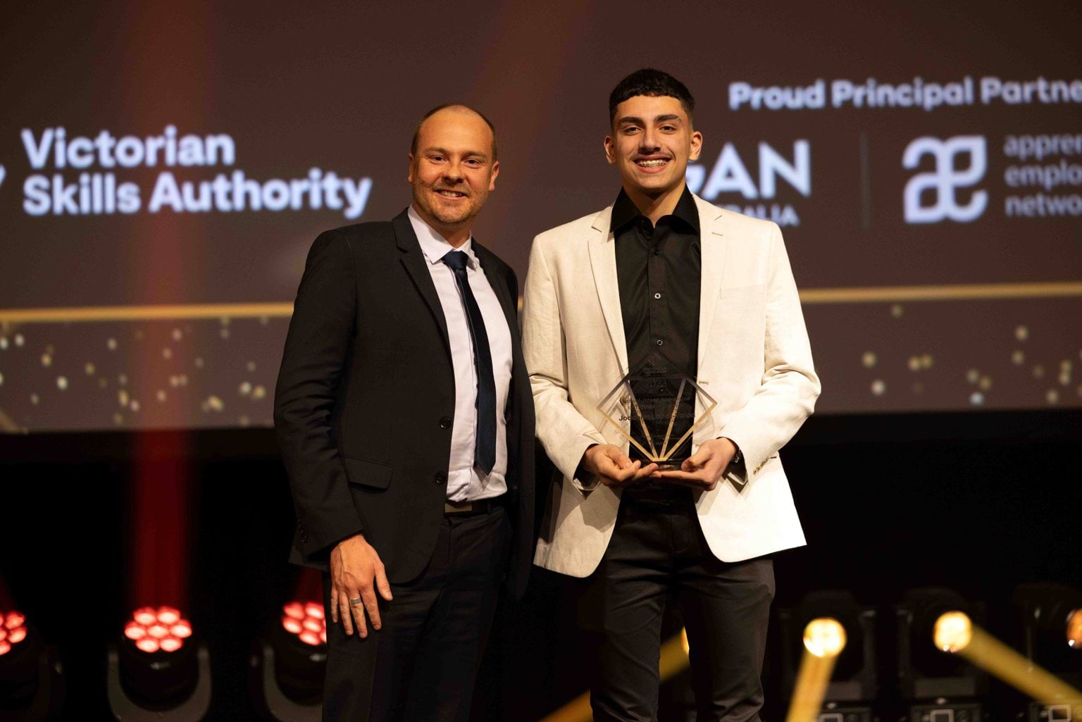 A winner of the 2023 Victorian Training Awards holding his trophy