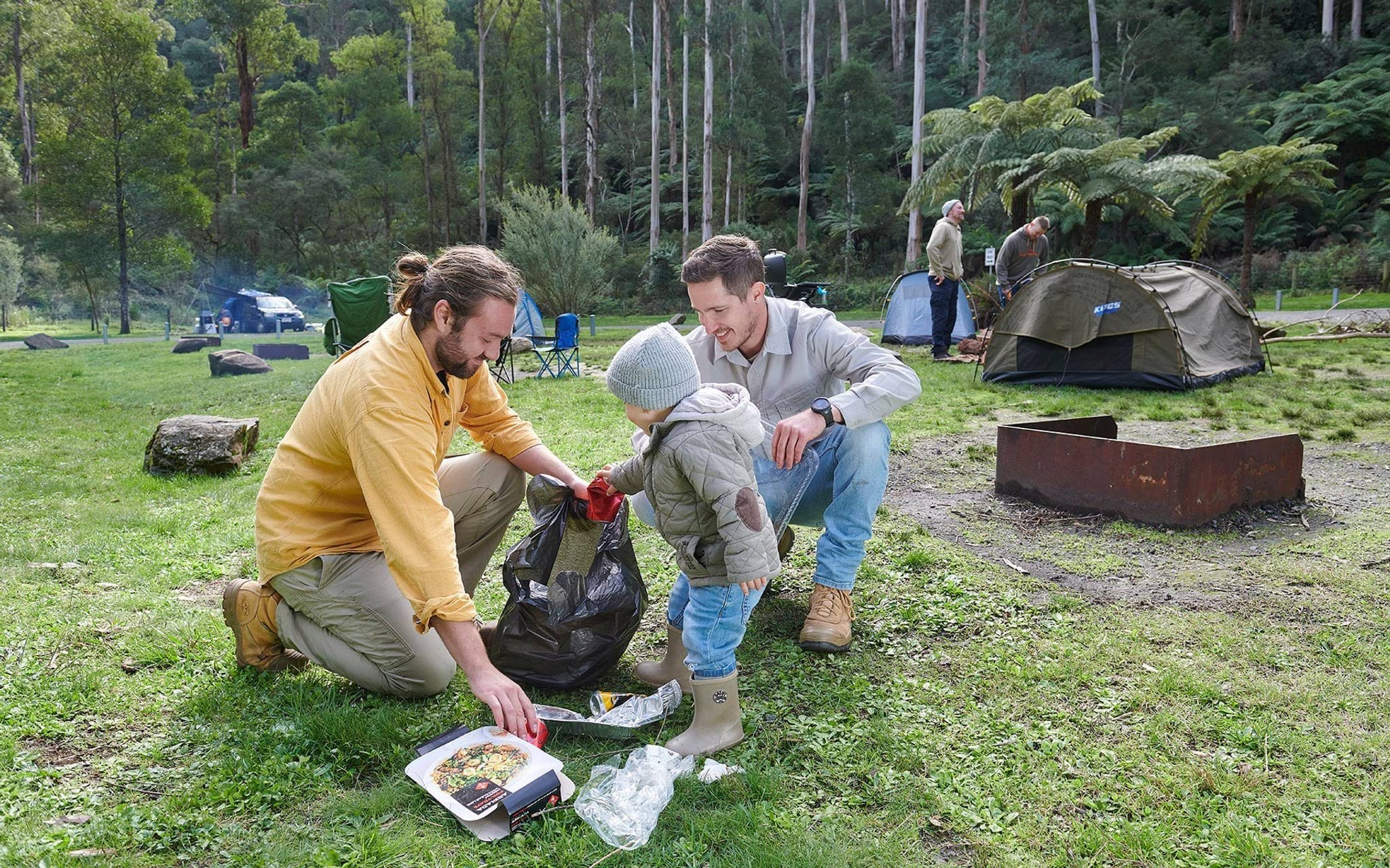 Campers cleaning up rubbish at campsite