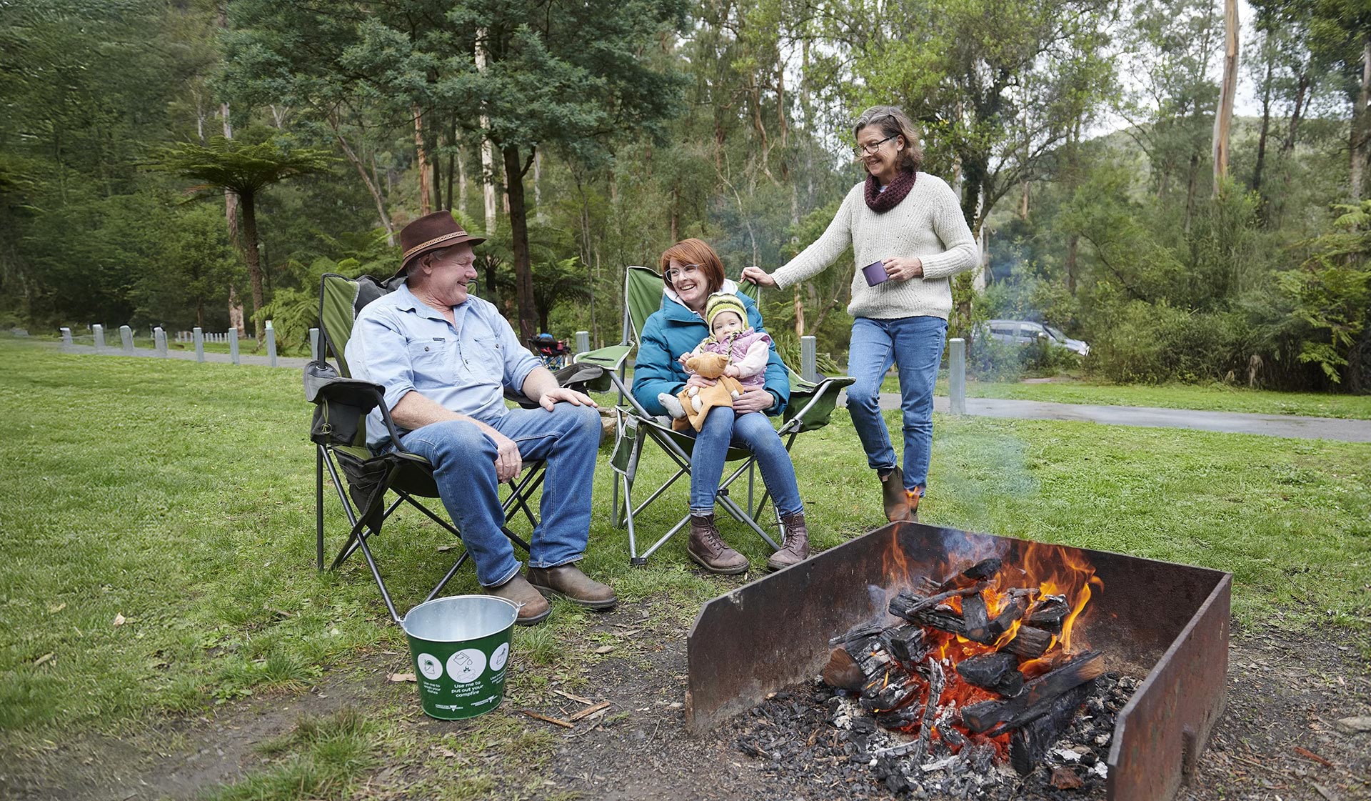 Campers around campfire with safety measures
