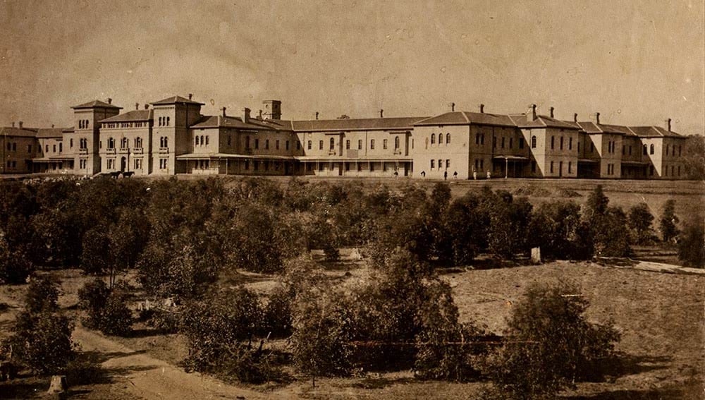 Colour photo of an old white building at time of official opening in 1867