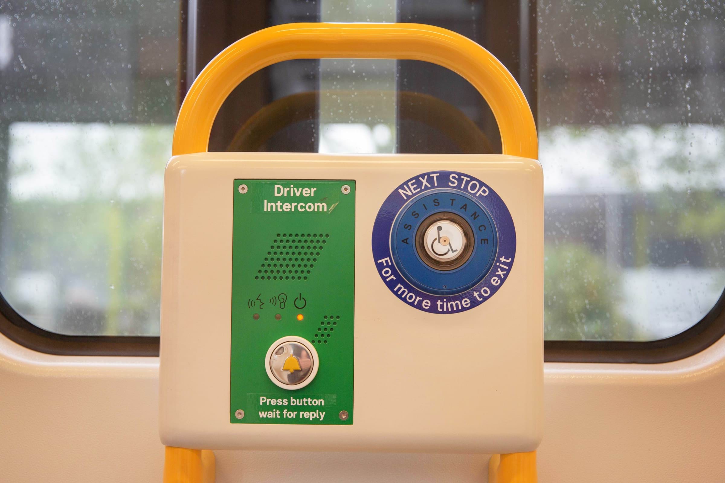 Image of two assistance buttons on a tram. To the left is the button that connects to the driver intercom, to the right, a button for the next stop for more time to exit.