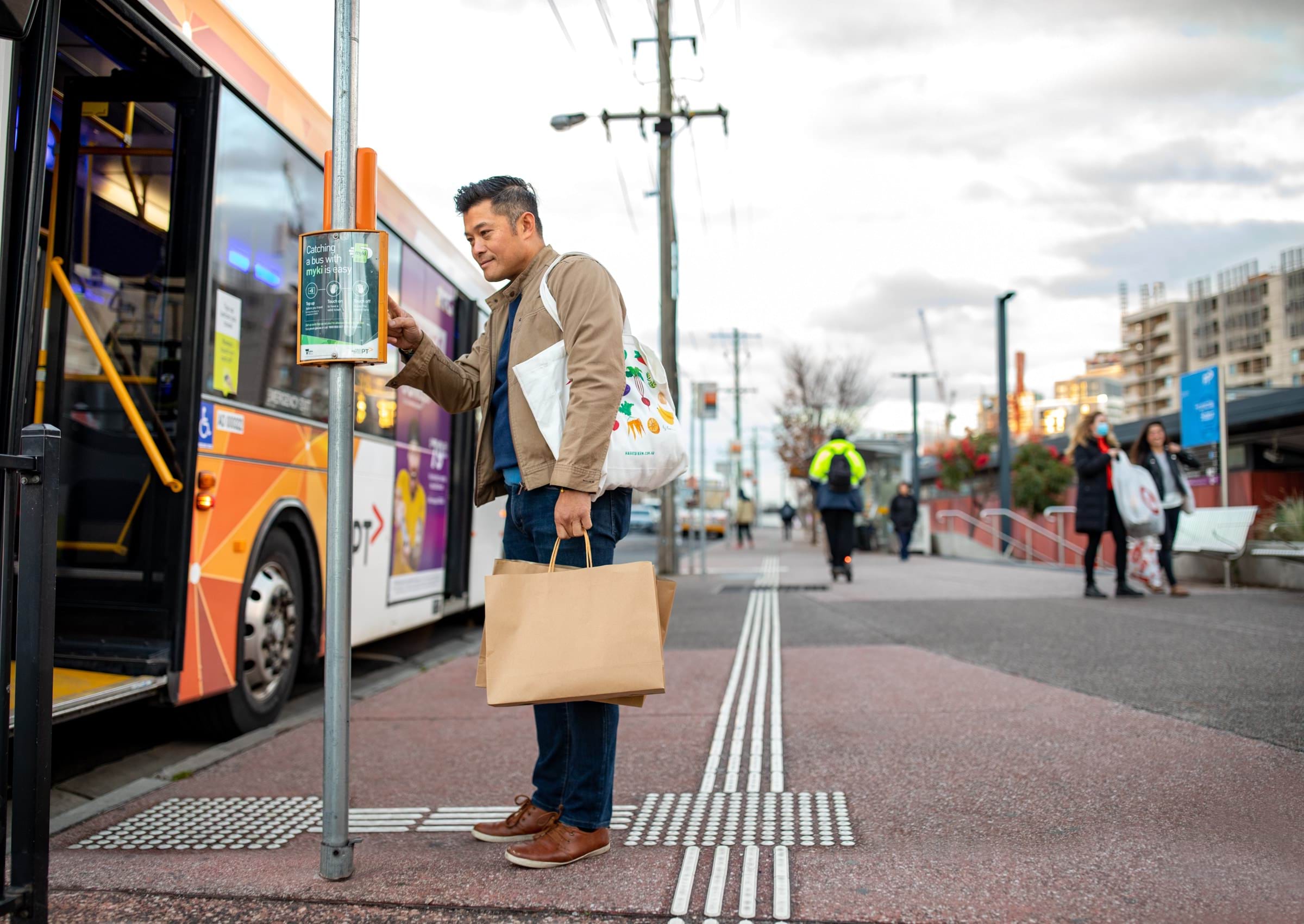 A person viewing the information sheet at a bus stop.