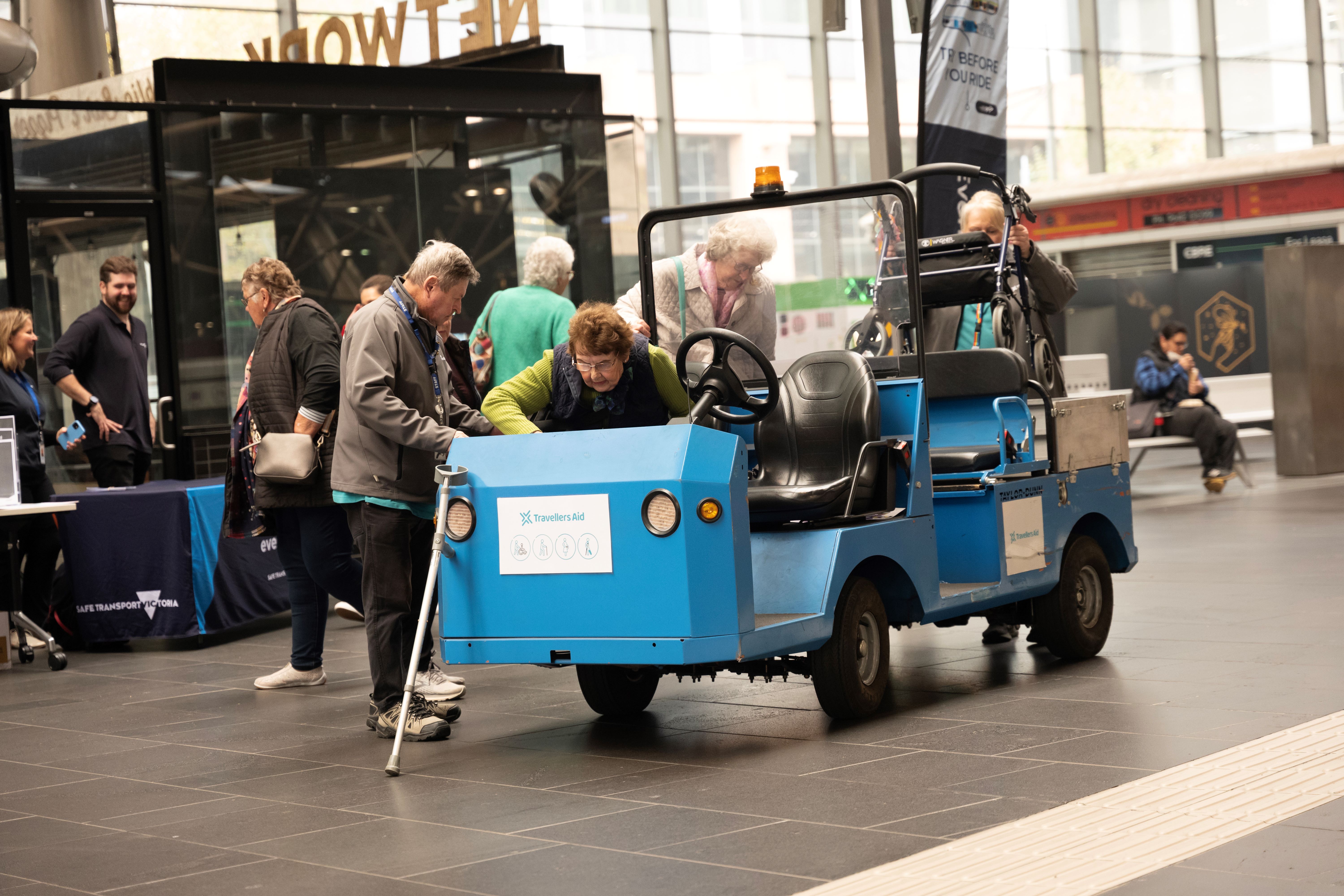 Image shows people boarding a Travellers Aid buggy at Southern Cross Station at the Try Before You Ride event.