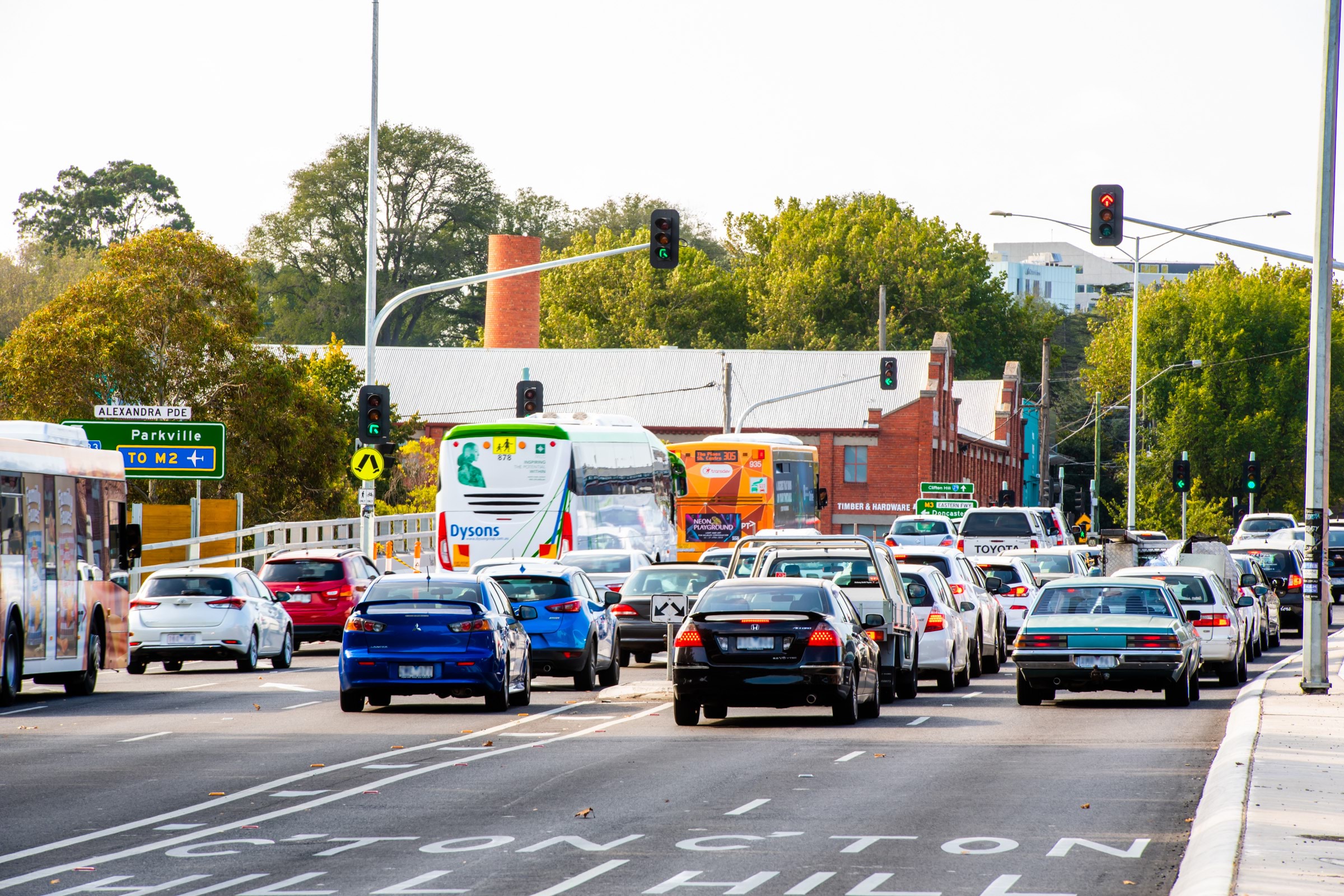 Image of car and bus traffic on a metropolitan road.