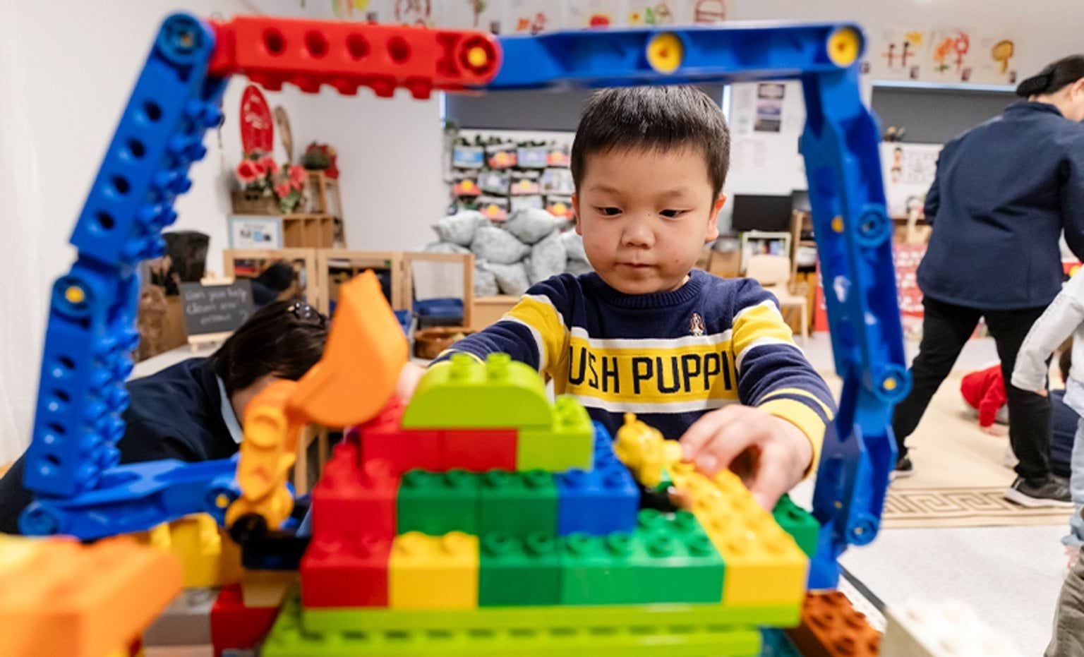 A child building a digger with blocks