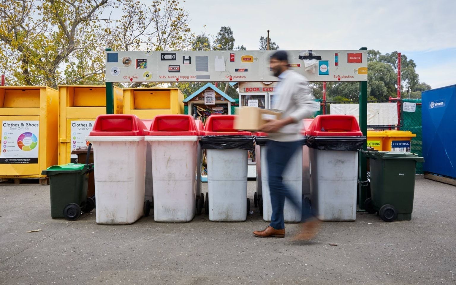 Man carrying box to sorting bins at a transfer station