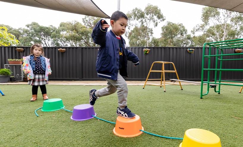 Child stepping on balance training equipment