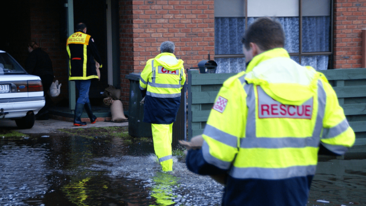 Emergency responders putting sandbags near a house