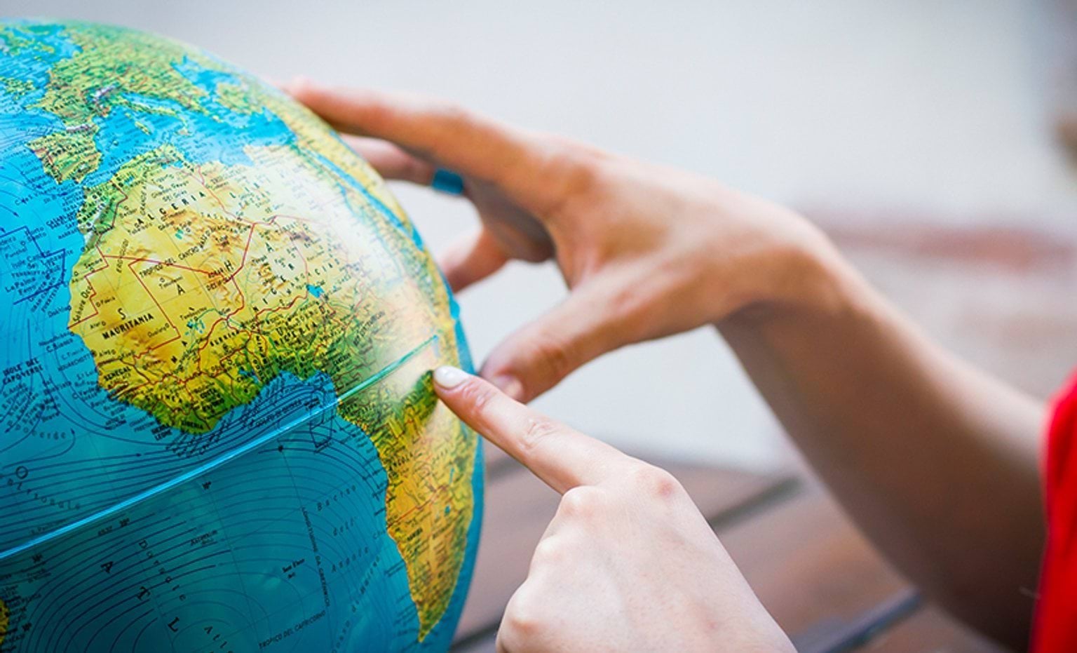 Hands exploring a globe