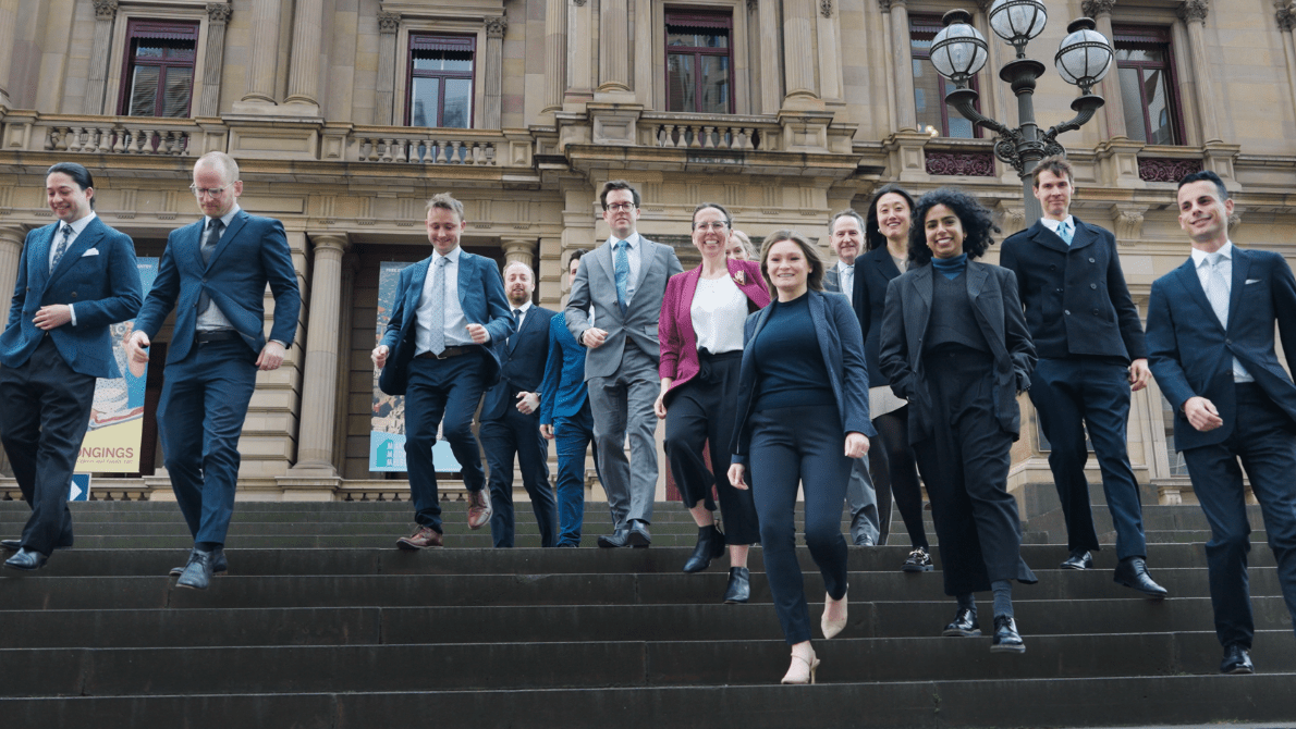 Office of the General Counsel representatives standing on steps of historic building in Melbourne CBD