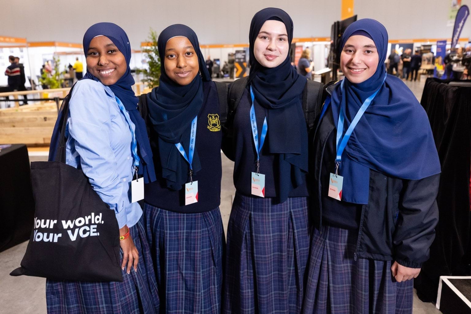 Female students with Your World, Your VCE merchandise