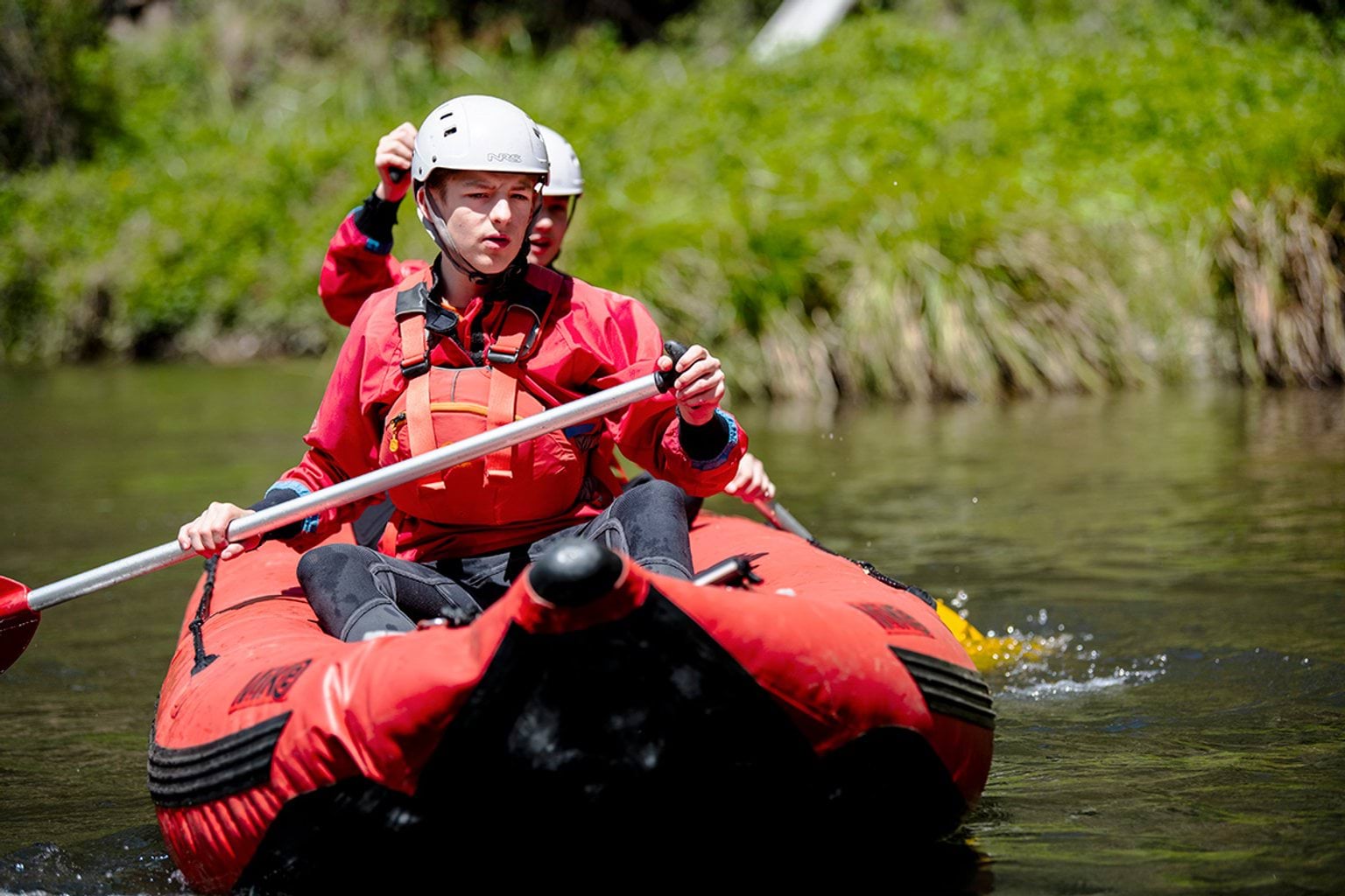 Students on blow up raft moving down river