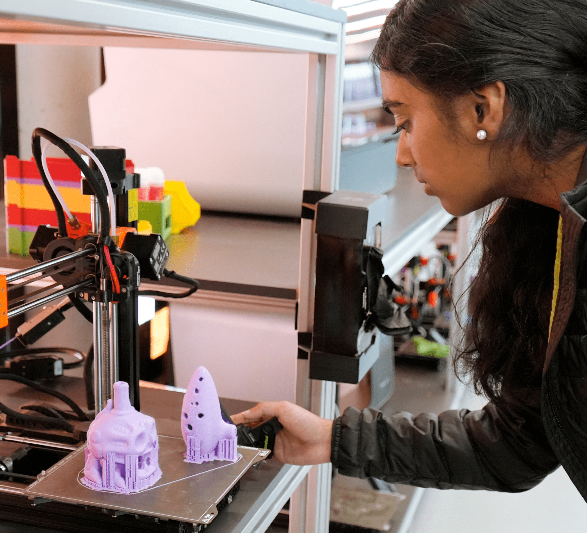 Student using a 3D printer to produce plastic objects