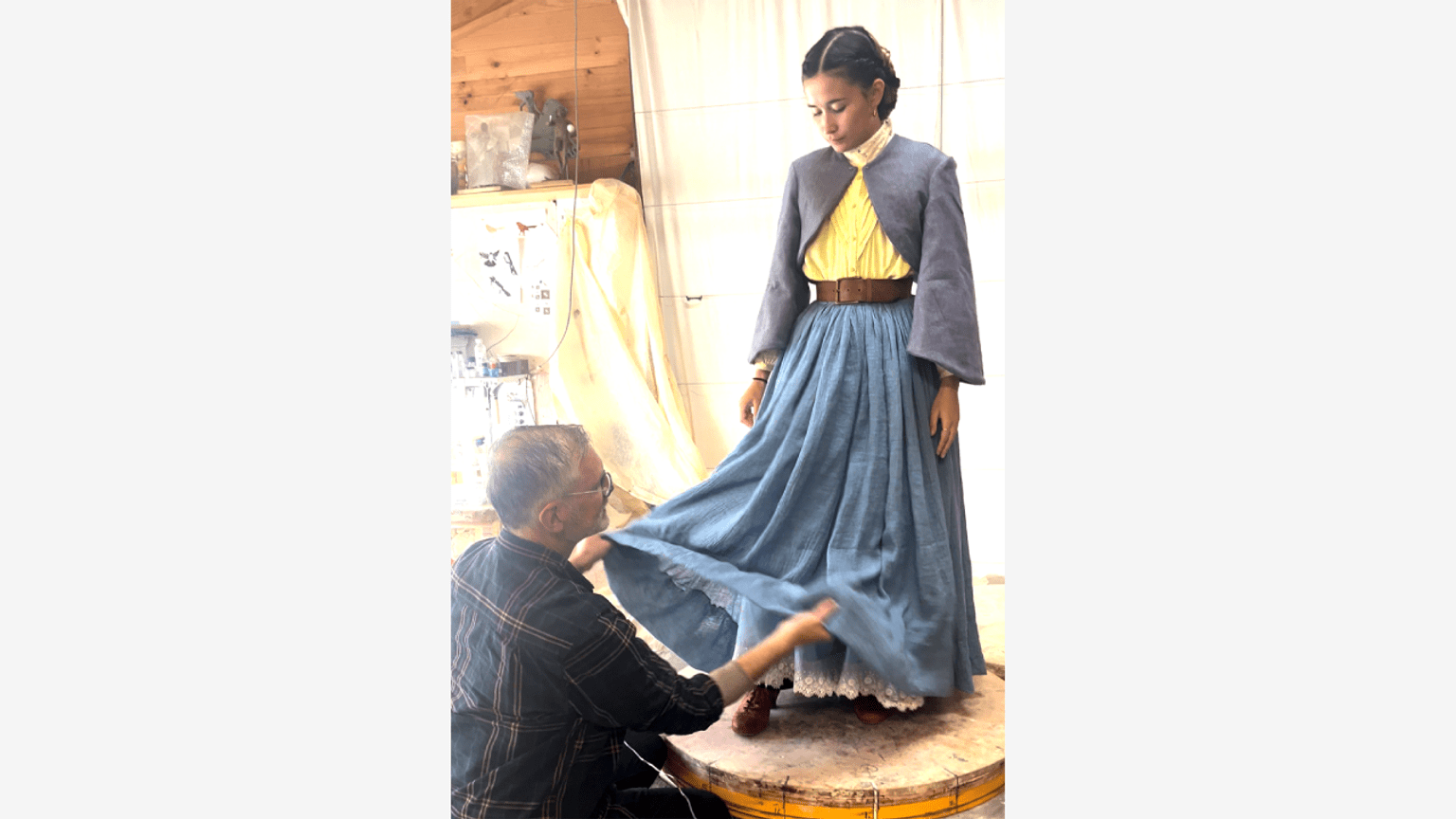Barbara Rae Period costume conservator Larry Edwards adjusts skirt with life model