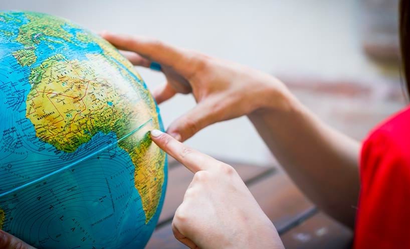 Hands exploring the globe