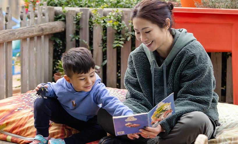 An educator reading a book t a child