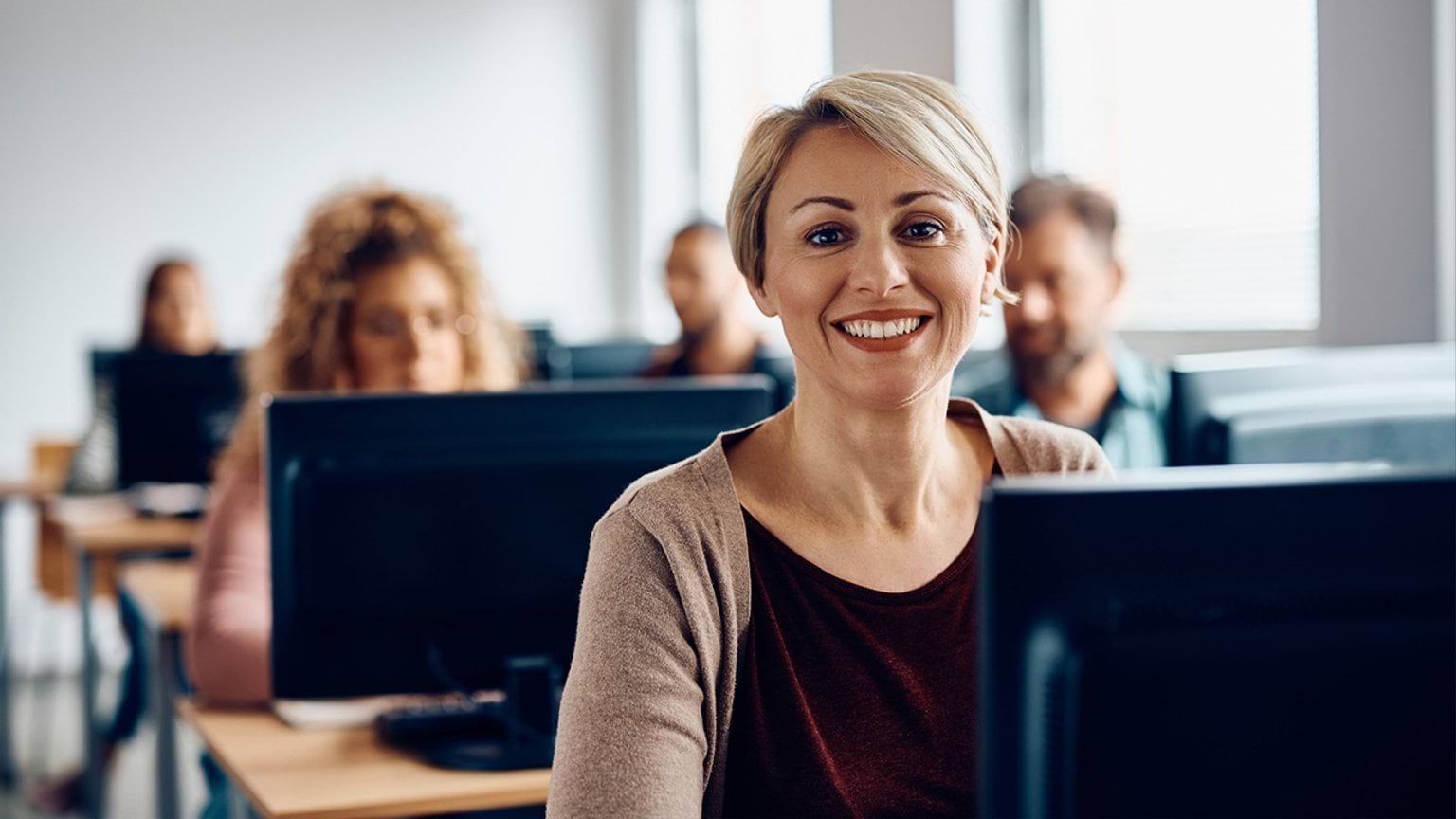 Person sitting behind a desktop computer in an adult learning environment 