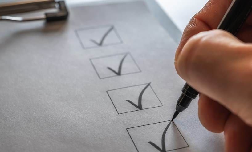 A checklist on a clip board being ticked off