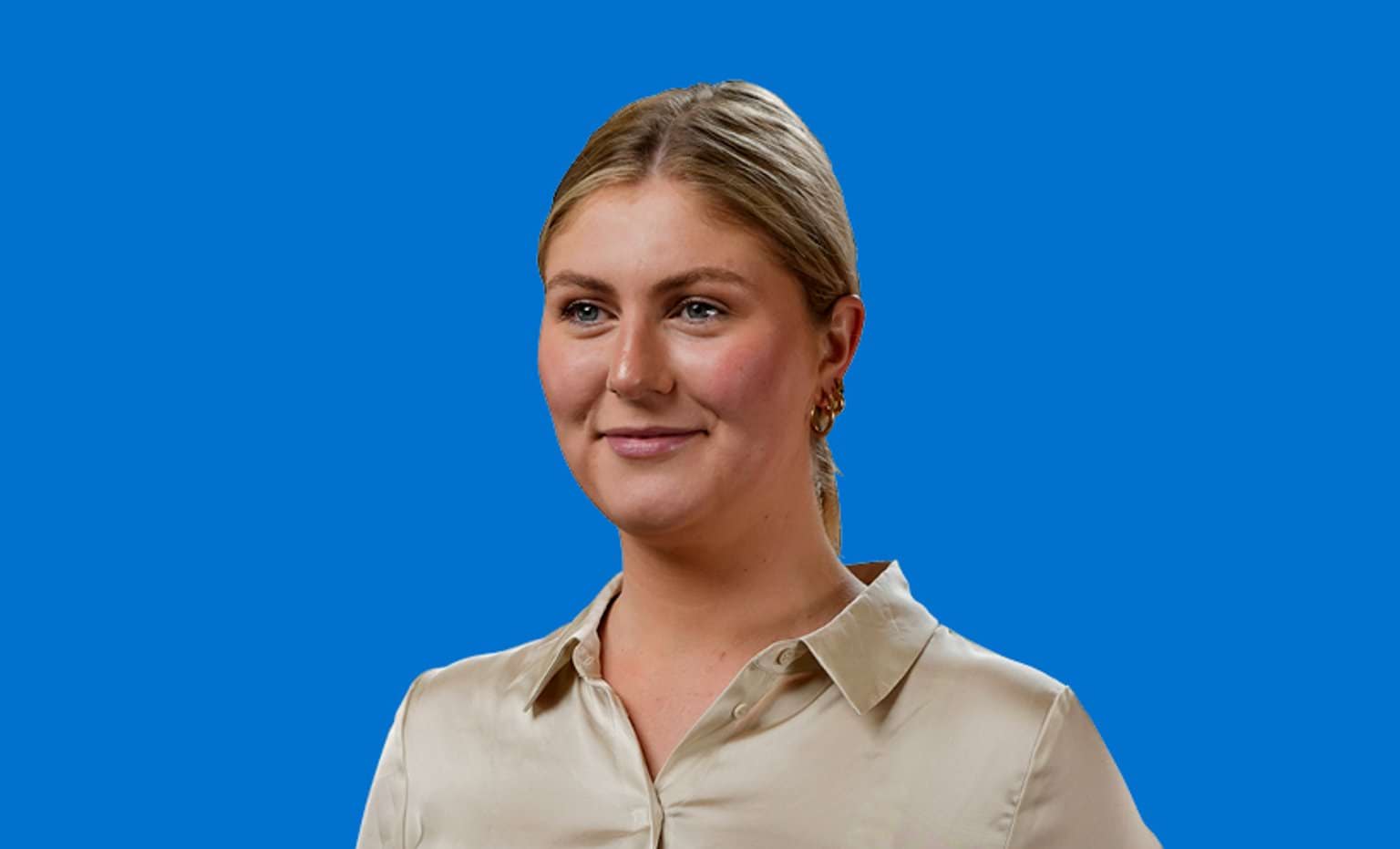 A graduate smiling headshot with a blue background 