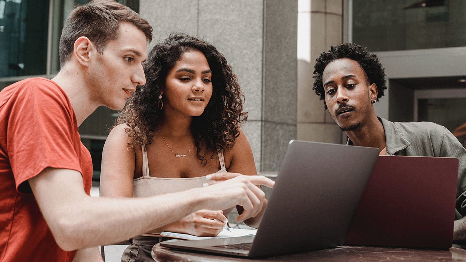 Three people working on laptop