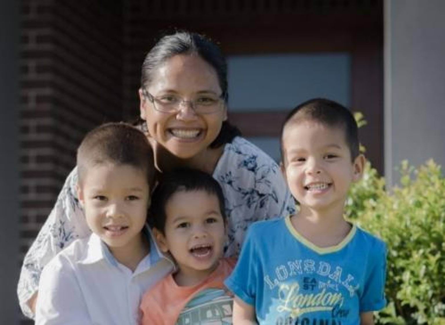 Woman behind 3 children