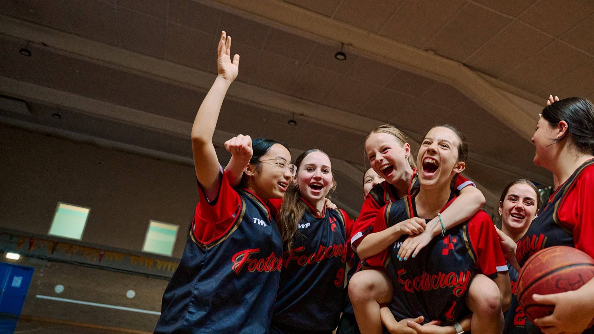 Students celebrating in their basketball uniforms
