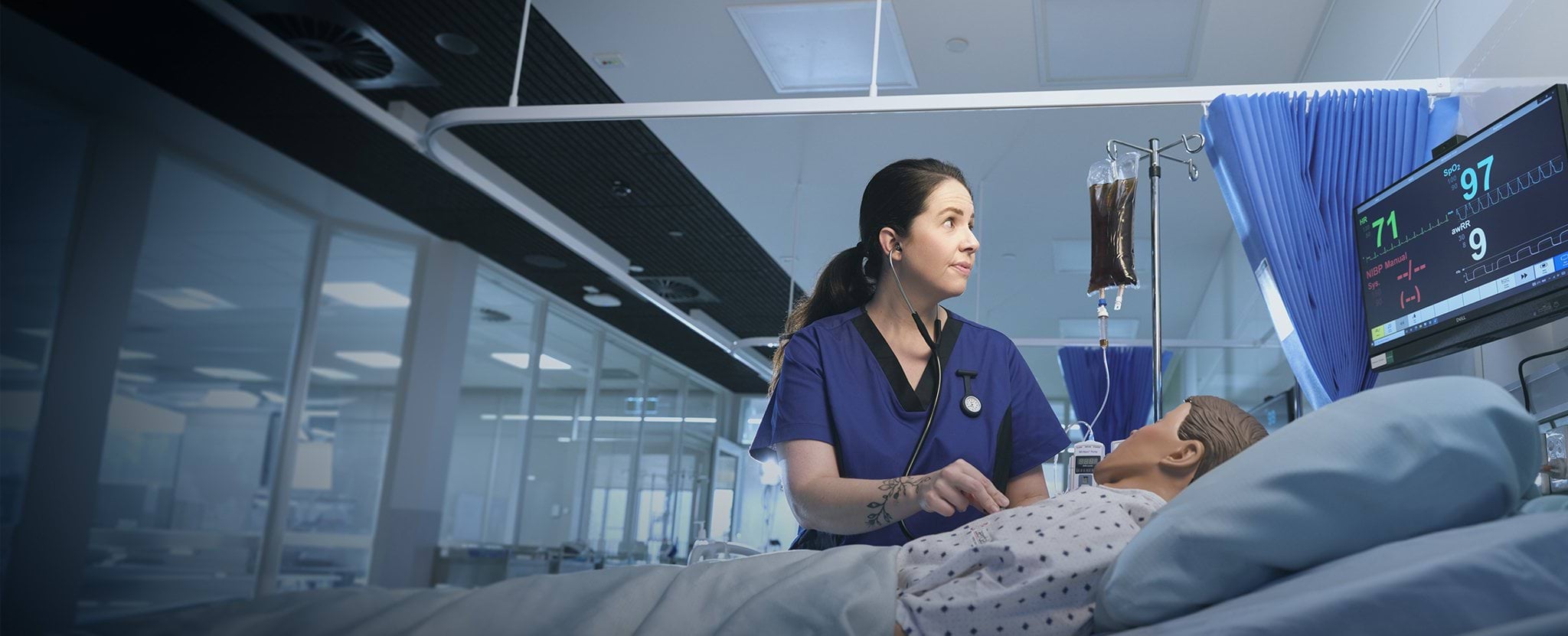 Nurse stands beside hospital bed checking a patient