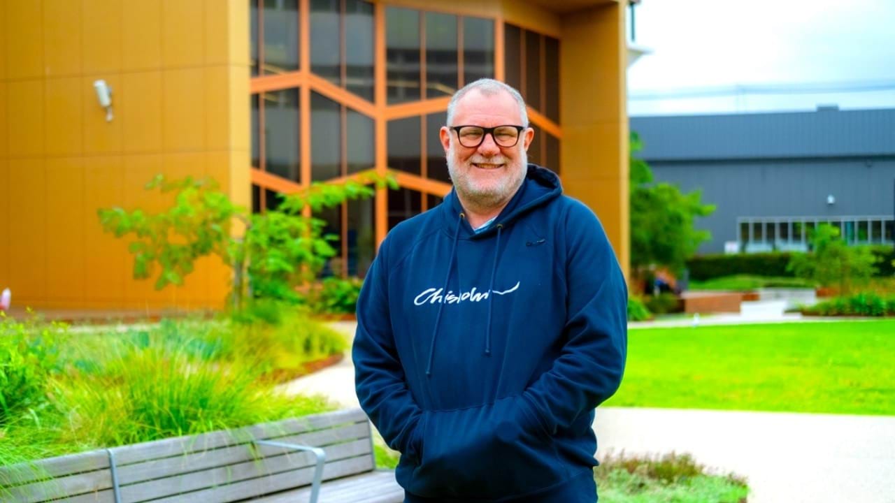 Chris smiling and standing outside Chisholm TAFE.
