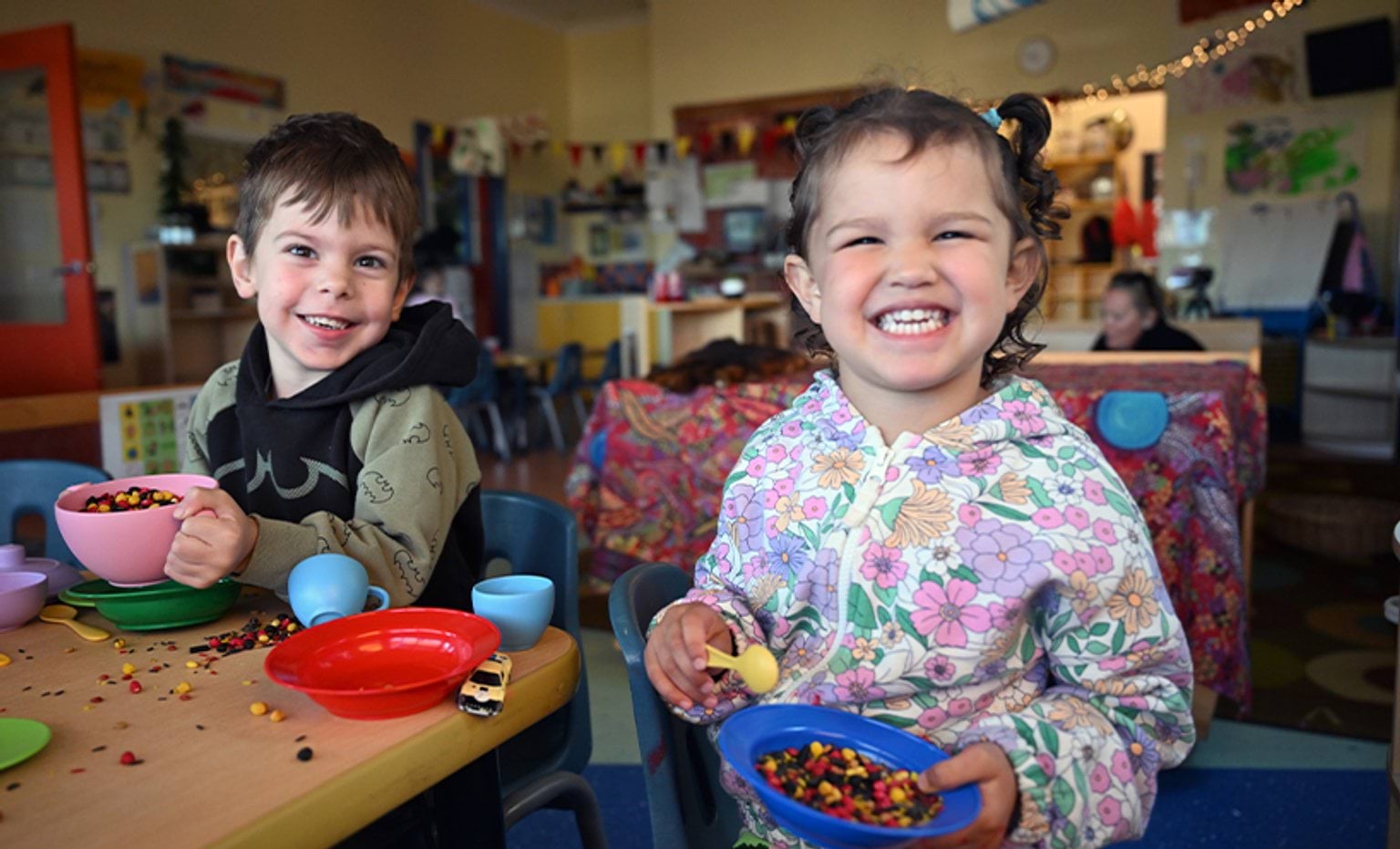 Two children playing with resources and smiling