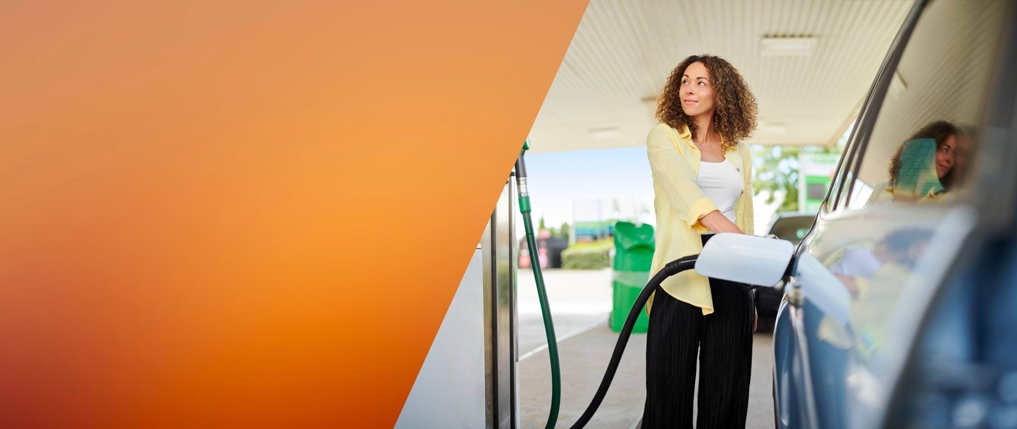 Image of a woman filling up a car at a service station