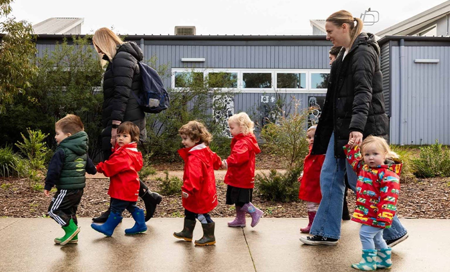 Children accompanied with adults while walking on footpath