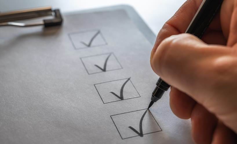 A checklist on a clip board being ticked off