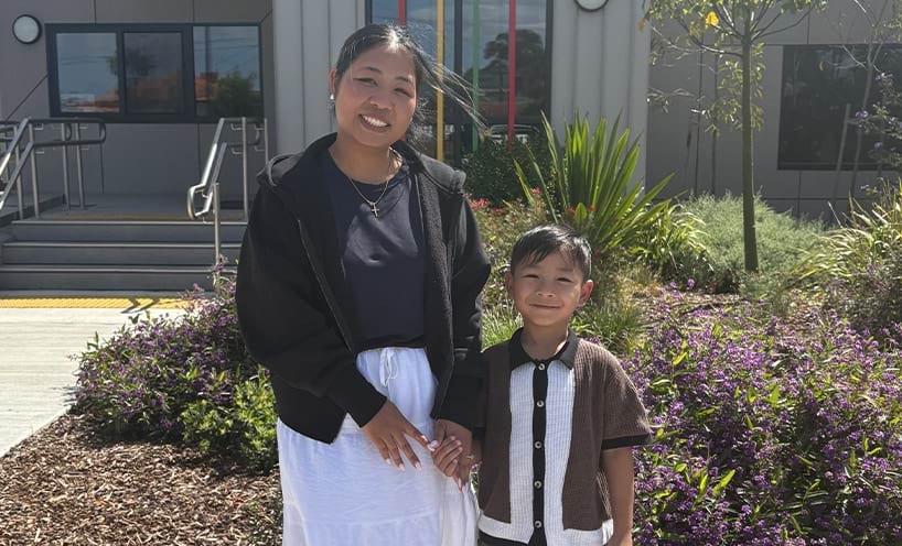 A child standing beside an adult, smiling