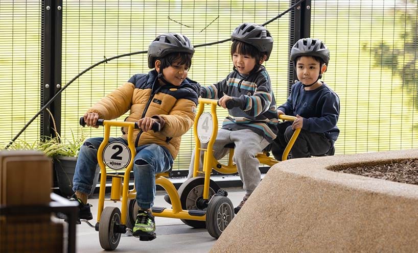Three children riding tri cycles