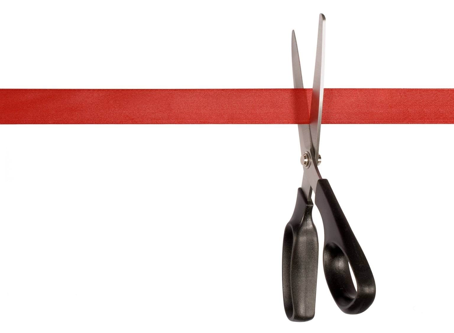 Scissors cutting red tape