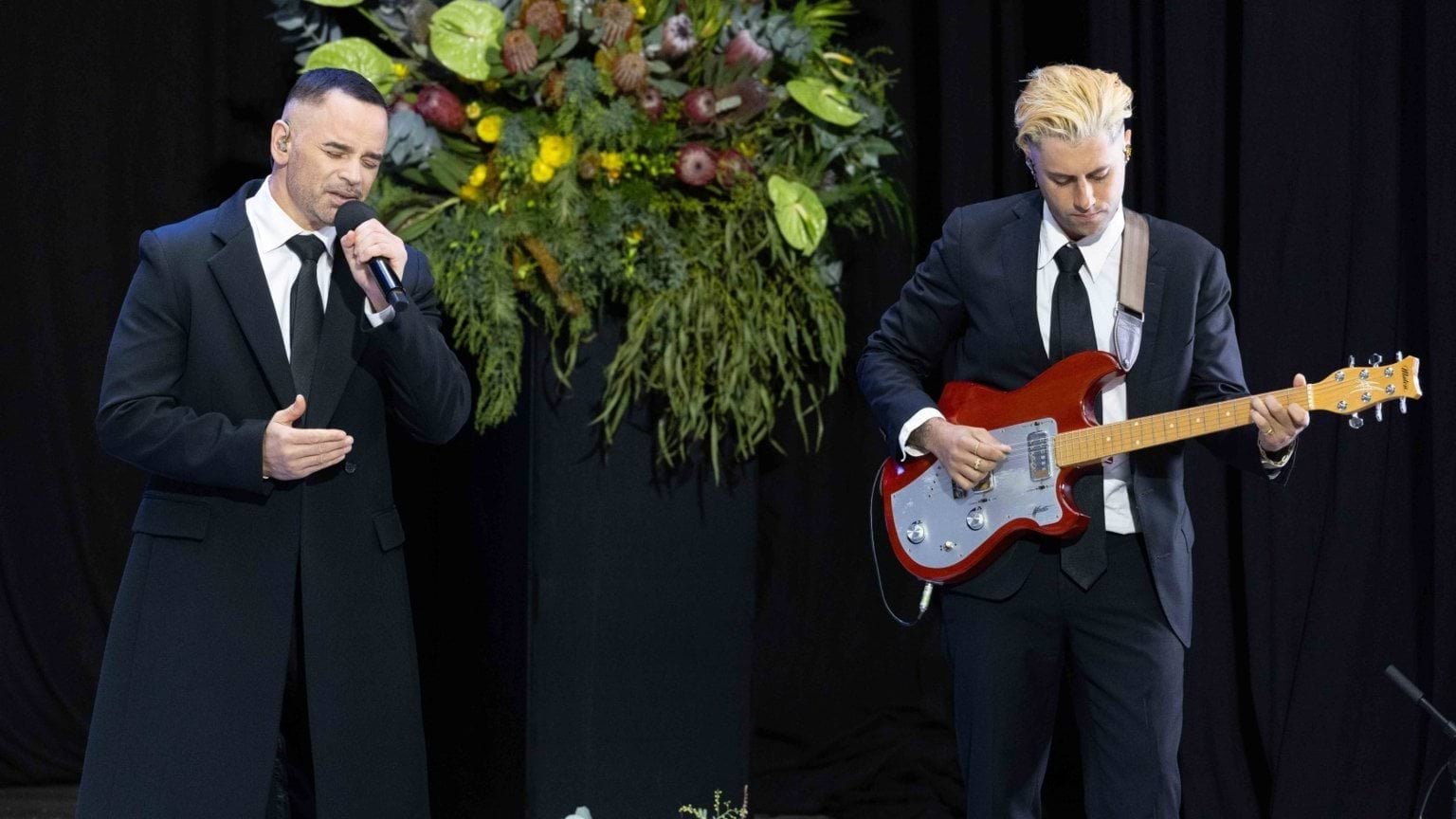 Singer Gary Pinto performs at Neal Daniher AO's State Funeral Service with a guitarist next to him