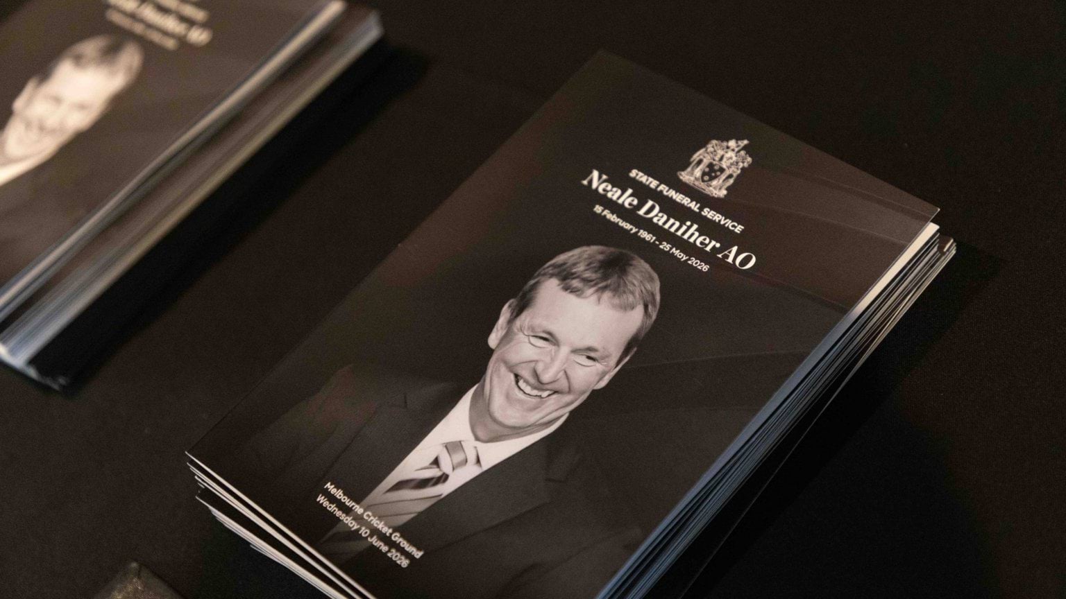 The order of service booklet for Neale Daniher AO's State Funeral Service, with a photo of Neale smiling on the front