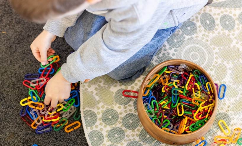A child playing with colourful links