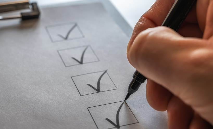 A checklist on a clipboard being ticked off