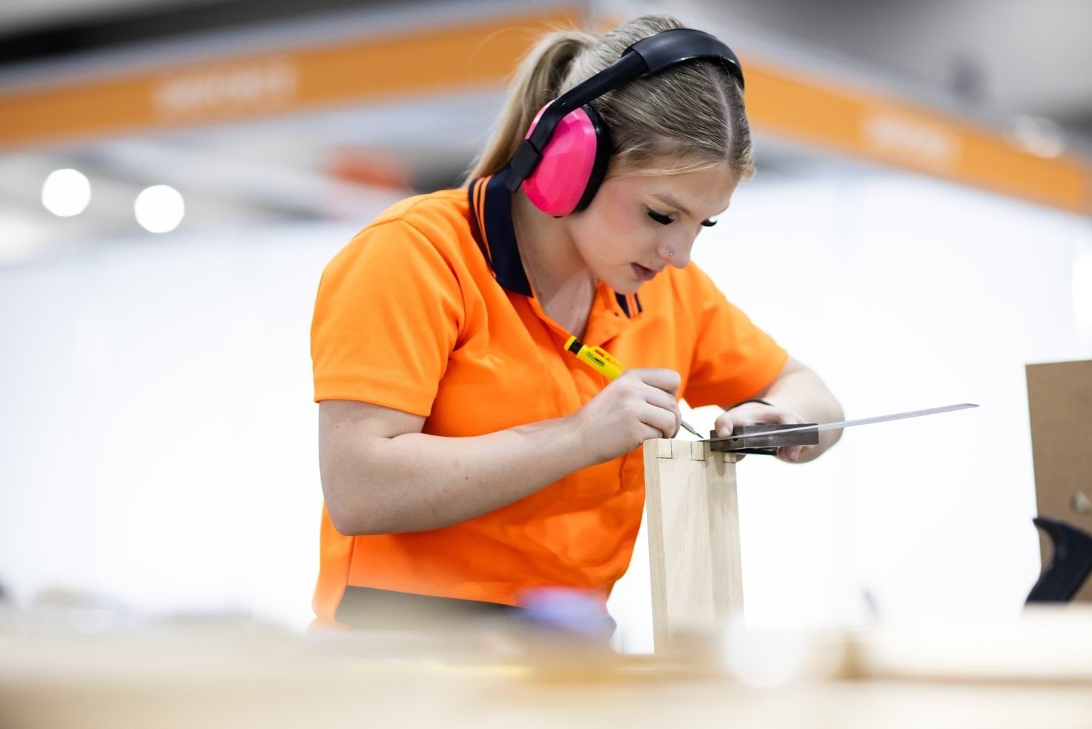 Female student taking carpentry measurements