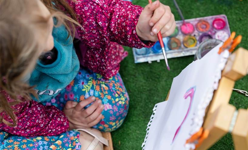A child painting on a small easel