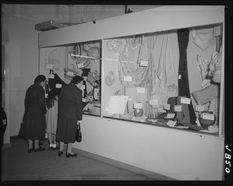 Black and white image of people looking at crafts.